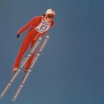 Ski jumper in a red jumping suit.